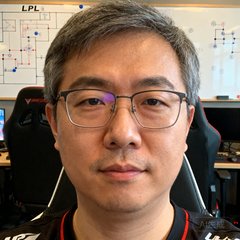 LPL某战队主教练李伟的头像照片，一位戴着眼镜的中年男子，背景是战队训练室的战术白板